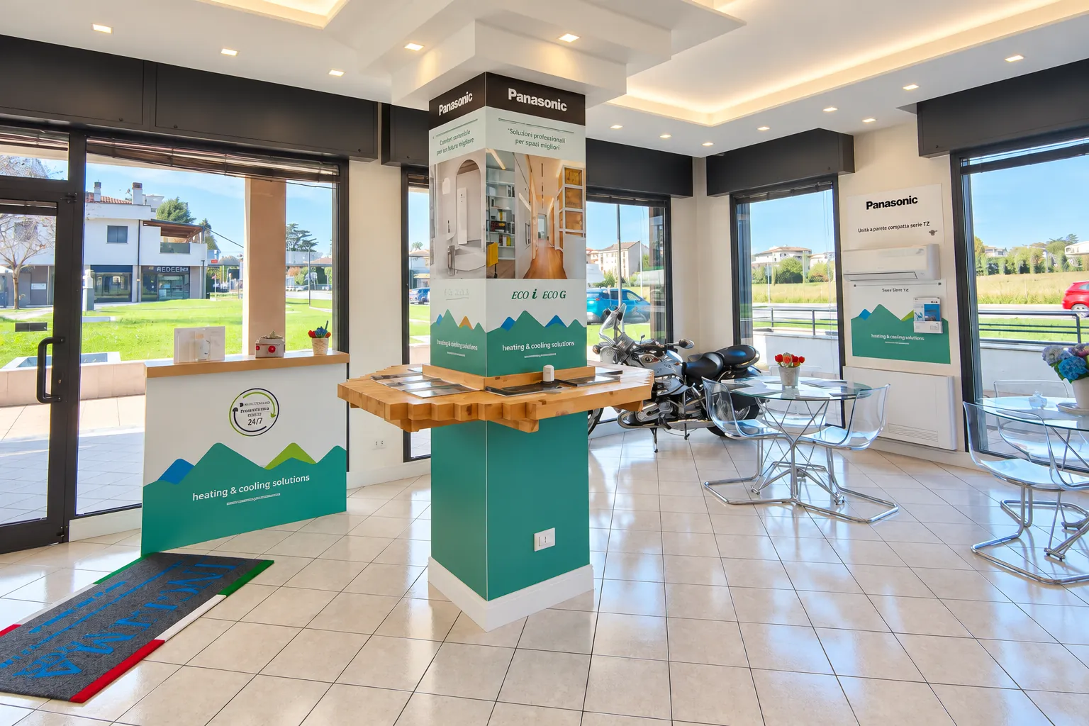 Lo showroom luminoso con ampie vetrate, totem Panasonic e area incontri